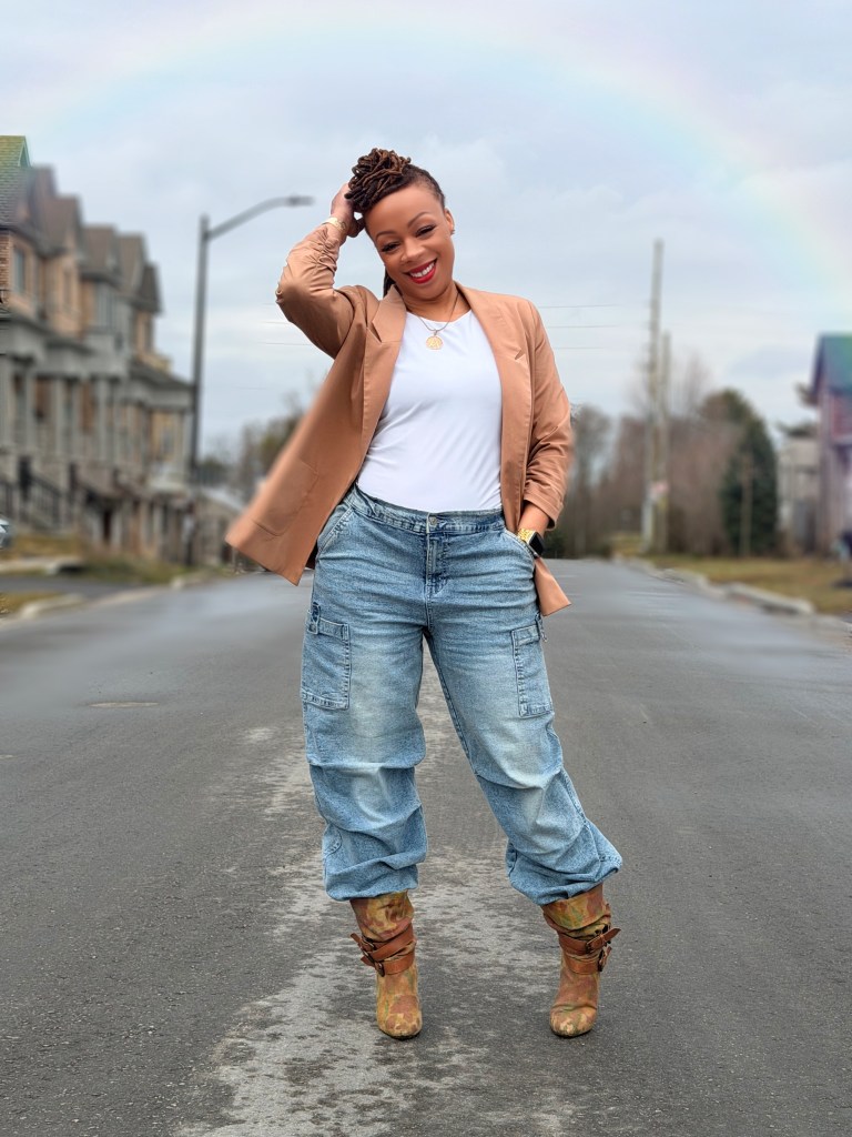 Angel Deen standing confidently outdoors in a camel blazer smiling, personal growth and transformation for women over 40